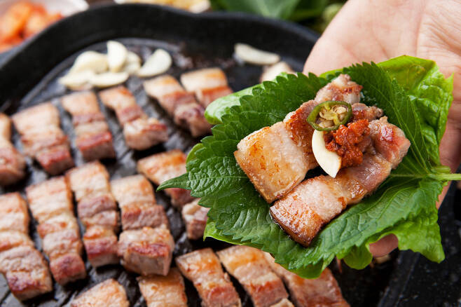 Grilled Korean pork belly wrapped in a perilla leaf with garlic and ssamjang.