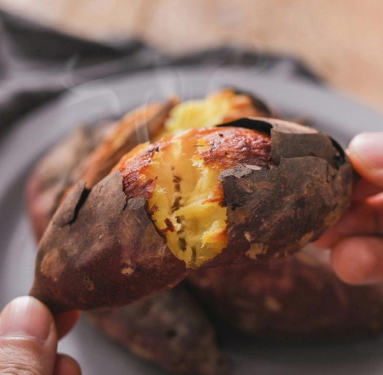 Steaming roasted sweet potato split open by hand